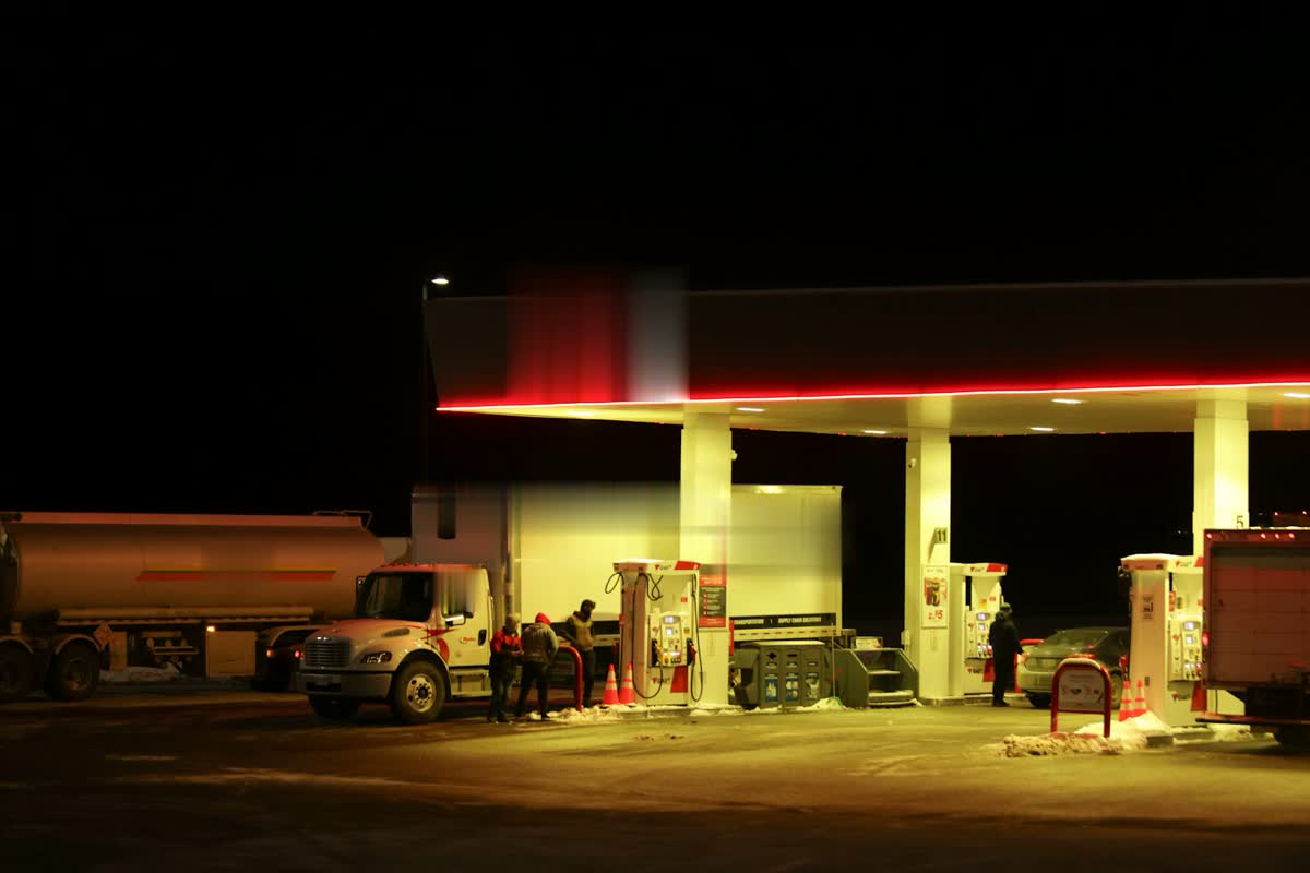 A fuel station at night with trucks filling up