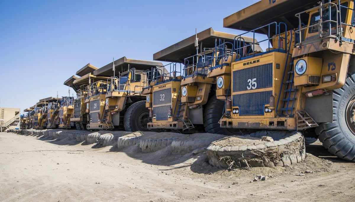 Mining haul trucks parked in a row at a mine